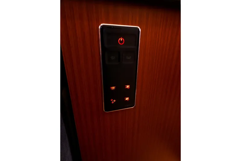 Slide: The Image of Control panel on 2016 Hanse 385 yacht with illuminated buttons on wooden surface. - 33