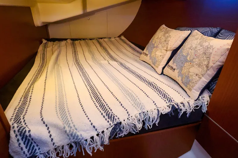 Slide: The Image of Cozy cabin bed in 2016 Hanse 385 yacht with nautical-themed pillows and striped blanket. - 50
