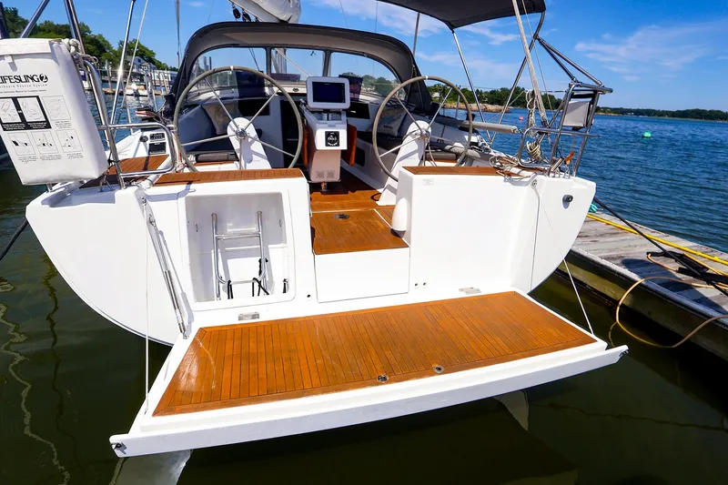 Slide: The Image of 2016 Hanse 385 sailboat with dual steering wheels, docked by the water. - 21