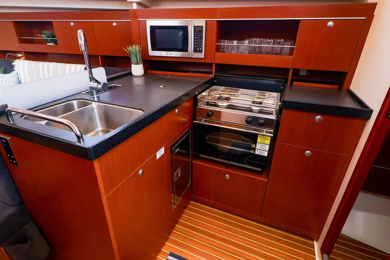Slide: The Image of Modern galley kitchen in 2016 Hanse 385 yacht with wood cabinetry and stainless steel appliances. - 25