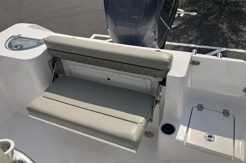 Slide: The Image of 2023 Sportsman Open 232 Center Console boat with cushioned seating and storage compartment. - 11