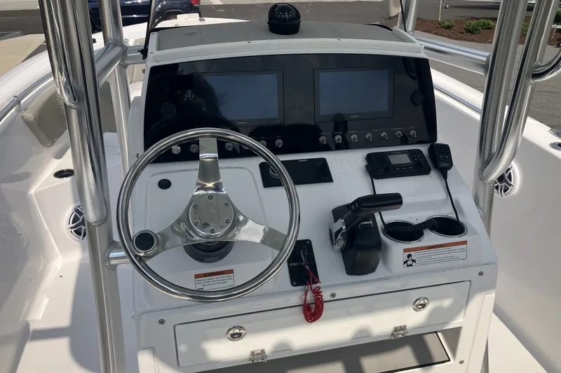 Slide: The Image of 2023 Sportsman Open 232 Center Console boat dashboard with steering wheel and controls. - 10
