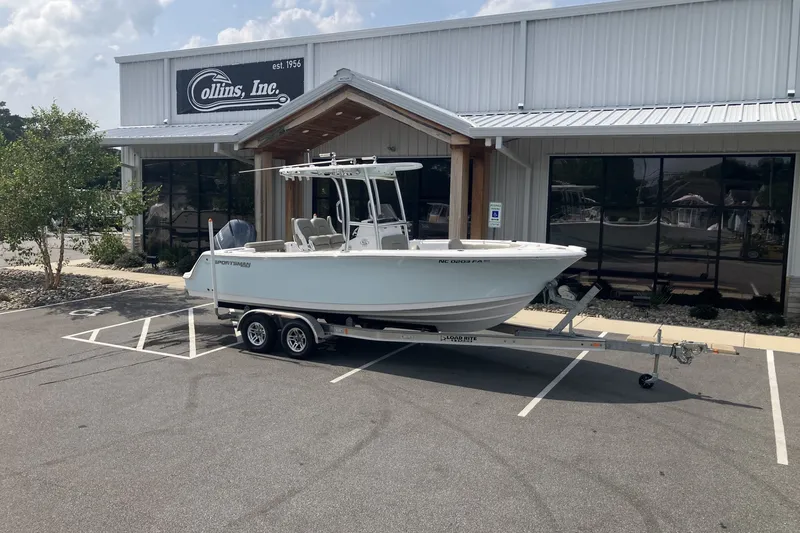 The Image of 2023 Sportsman Open 232 Center Console boat on trailer outside dealership. - 1