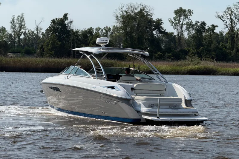 Slide: The Image of 2018 Cobalt R35 boat cruising on a scenic river with lush greenery. - 30