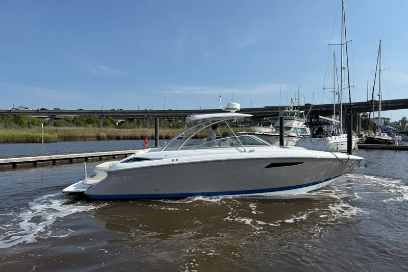 Slide: The Image of 2018 Cobalt R35 boat docked in marina, clear sky, bridge in background. - 2