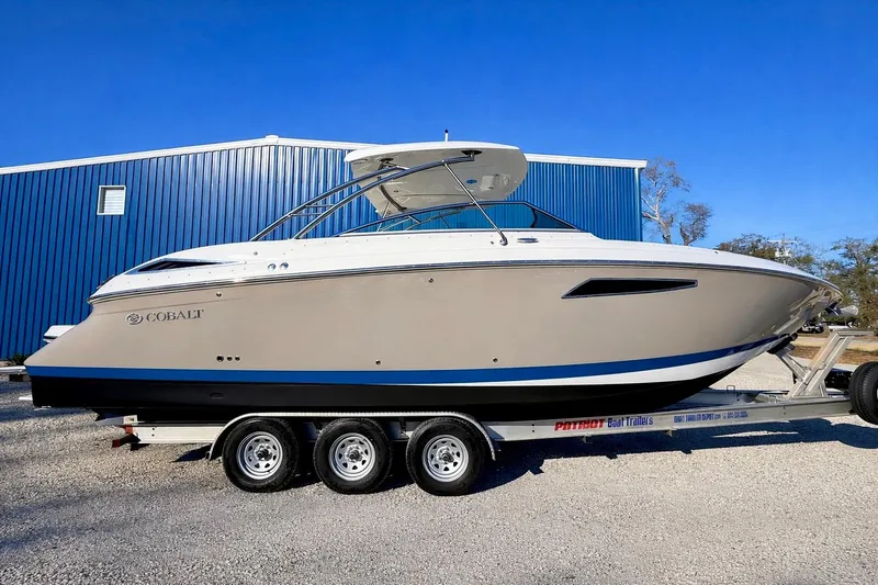 The Image of 2018 Cobalt R35 boat on trailer, parked near blue building under clear sky. - 2