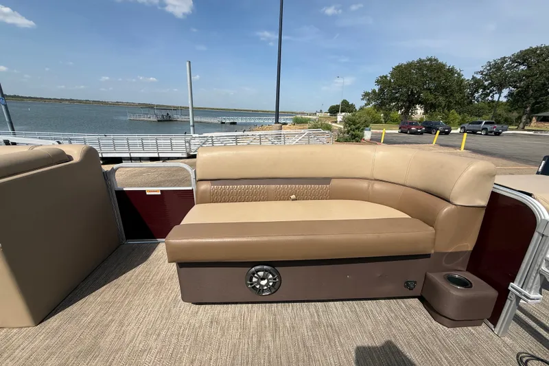 Slide: The Image of 2021 Godfrey Sweetwater 2286 FS pontoon boat with beige seating, docked by a serene lake. - 34