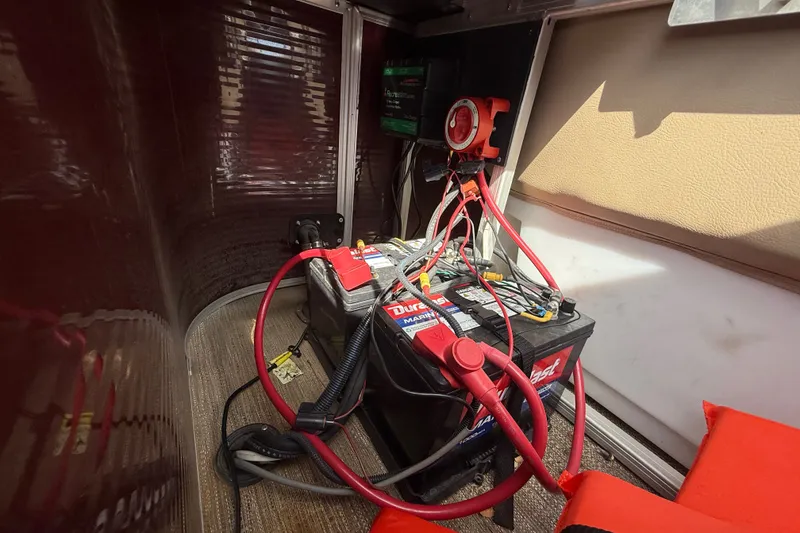 Slide: The Image of Battery setup in a 2021 Godfrey Sweetwater 2286 FS boat, featuring cables and connections. - 52