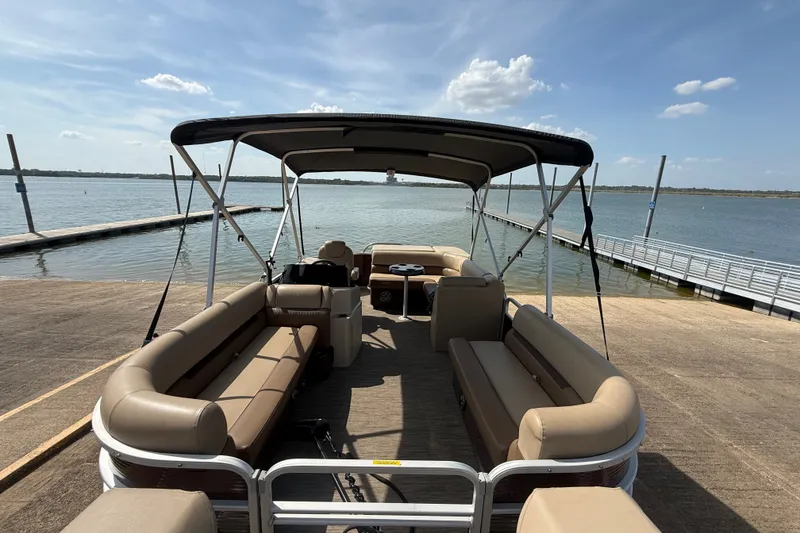 Slide: The Image of 2021 Godfrey Sweetwater 2286 FS pontoon boat docked by a serene lake under a sunny sky. - 10