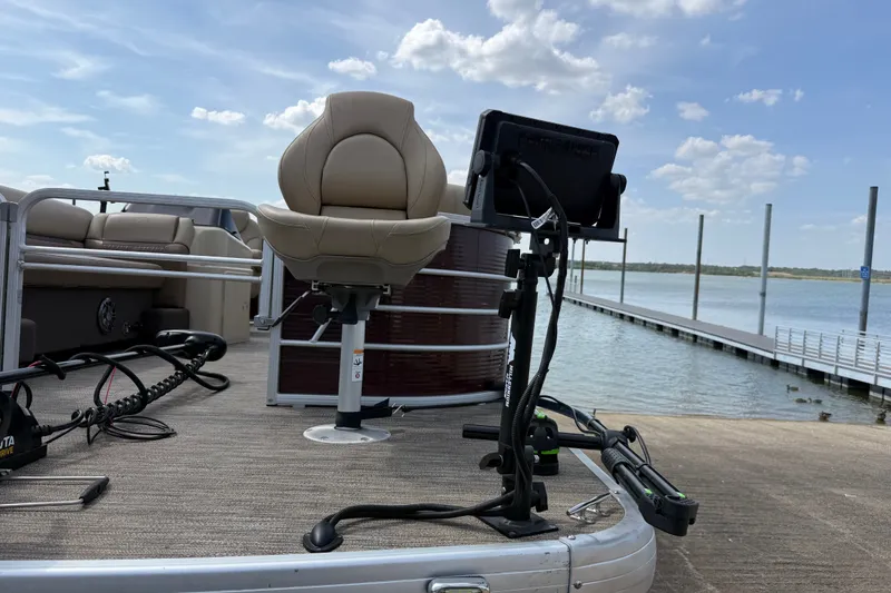 Slide: The Image of 2021 Godfrey Sweetwater 2286 FS pontoon boat with fishing chair and equipment by a dock. - 26