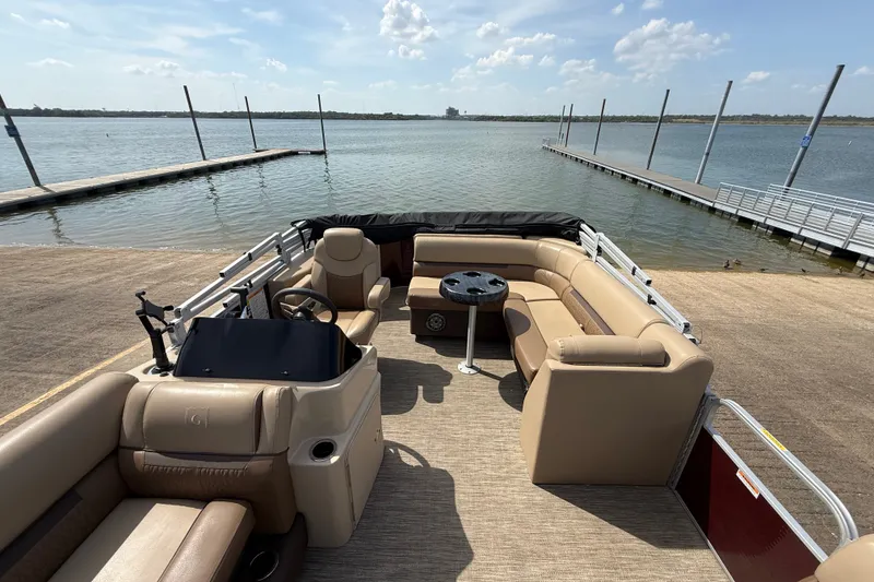 Slide: The Image of 2021 Godfrey Sweetwater 2286 FS pontoon boat at a lakeside dock under a clear sky. - 38