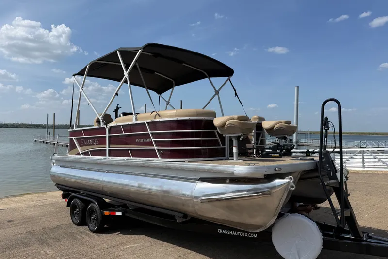 Slide: The Image of 2021 Godfrey Sweetwater 2286 FS pontoon boat on trailer by a lake. - 21