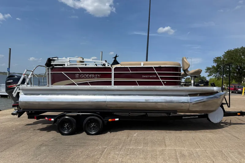 Slide: The Image of 2021 Godfrey Sweetwater 2286 FS pontoon boat on trailer under clear blue sky. - 6