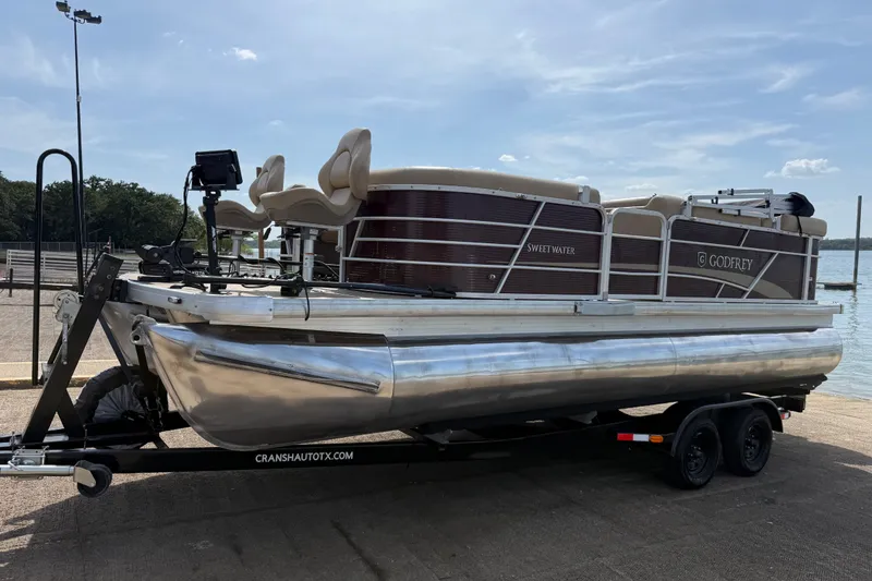 Slide: The Image of 2021 Godfrey Sweetwater 2286 FS pontoon boat on trailer by a lake. - 19