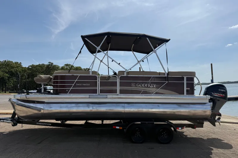 Slide: The Image of 2021 Godfrey Sweetwater 2286 FS pontoon boat on trailer by a lake. - 49