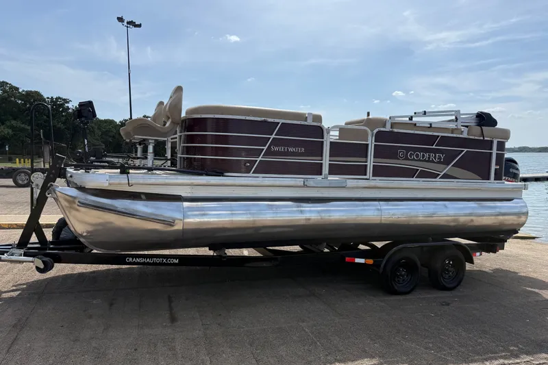 Slide: The Image of 2021 Godfrey Sweetwater 2286 FS pontoon boat on trailer by the water. - 20