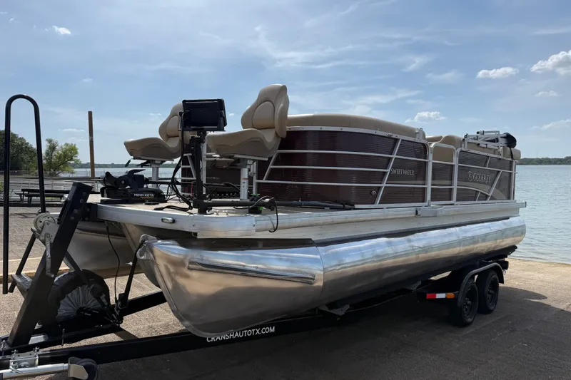 Slide: The Image of 2021 Godfrey Sweetwater 2286 FS pontoon boat on trailer by the lake. - 2