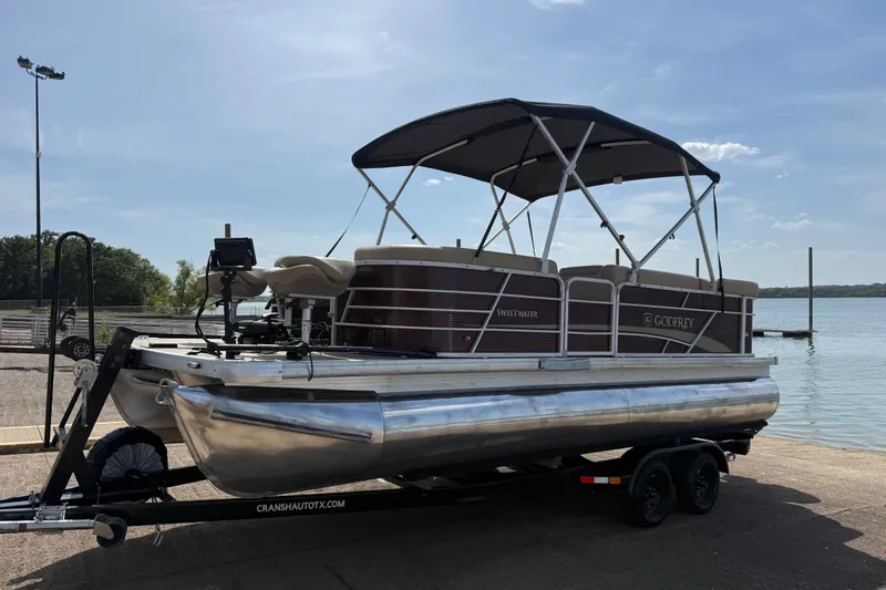 Slide: The Image of 2021 Godfrey Sweetwater 2286 FS pontoon boat on trailer by a lake. - 7