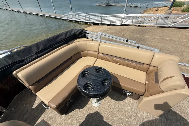 Slide: The Image of 2021 Godfrey Sweetwater 2286 FS pontoon boat with beige seating and black table by the dock. - 40