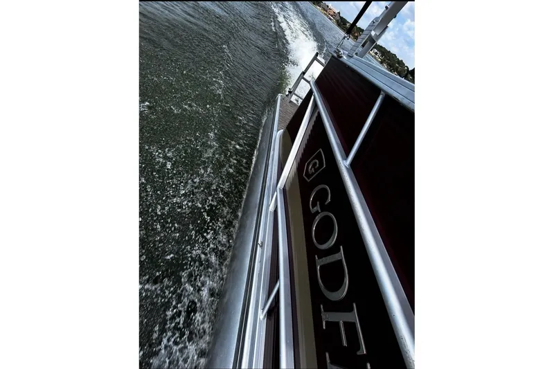 Slide: The Image of 2021 Godfrey Sweetwater 2286 FS pontoon boat cruising on water, side view. - 64
