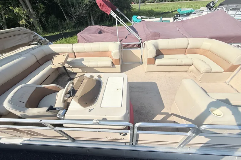 Slide: The Image of 1998 Harris FloteBote 220 Classic pontoon boat with beige seating and steering console. - 2