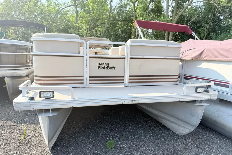 Slide: The Image of 1998 Harris FloteBote 220 Classic pontoon boat with beige and brown accents, parked outdoors. - 3