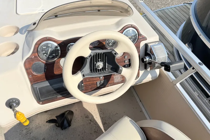 Slide: The Image of 1998 Harris FloteBote 220 Classic boat dashboard with steering wheel and controls. - 9