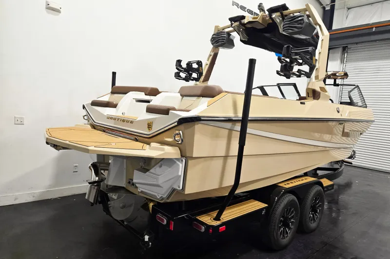 Slide: The Image of The image shows a modern motorboat on a trailer in a warehouse. It features sleek design with beige accents, multiple seats, and a tower. - 3