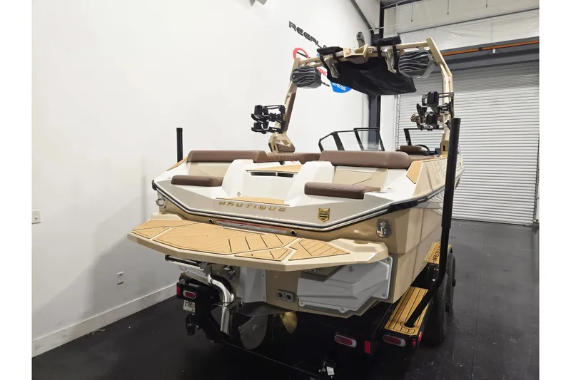 Slide: The Image of The image shows a 2027 Super Air Nautique S23 boat in a warehouse. It features a sleek design with a sturdy tower and modern seating. - 4