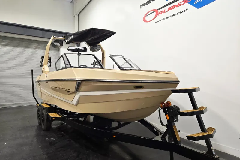 Slide: The Image of The image shows a 2027 Super Air Nautique S23 boat on a trailer in a showroom. - 2