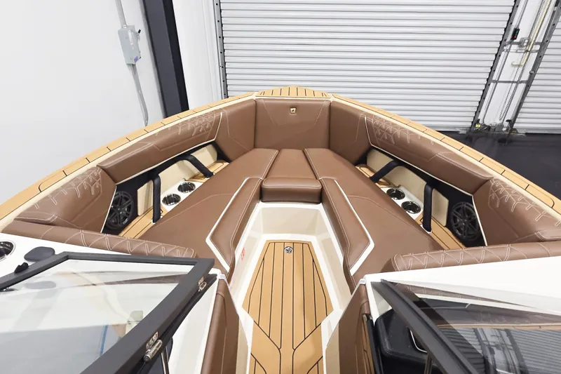Slide: The Image of The image shows the bow of a 2027 Super Air Nautique S23 with luxurious brown upholstery and speakers. - 6