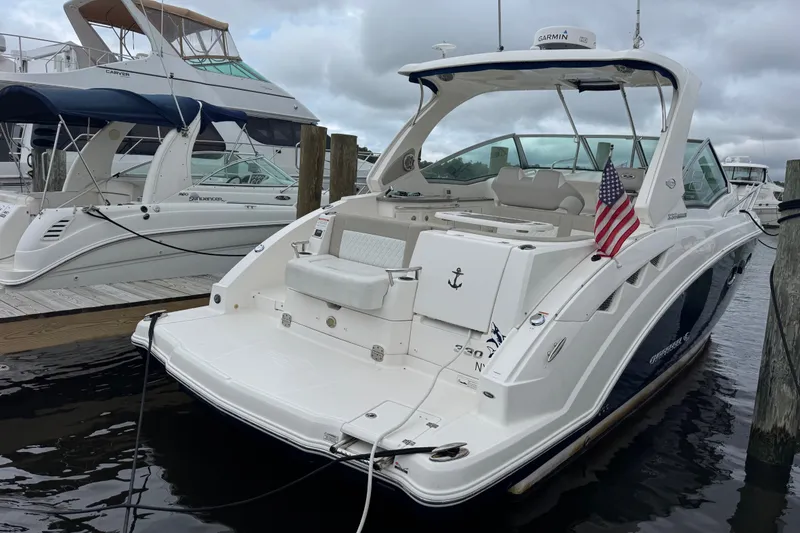 Slide: The Image of 2013 Chaparral 330 Signature boat docked, featuring sleek design and American flag. - 2
