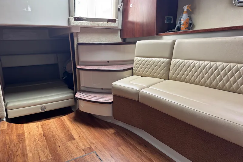 Slide: The Image of Interior of 2013 Chaparral 330 Signature boat with beige seating and wooden flooring. - 15
