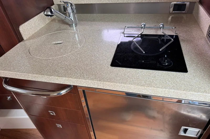 Slide: The Image of 2013 Chaparral 330 Signature yacht kitchenette with sink and stovetop. - 17