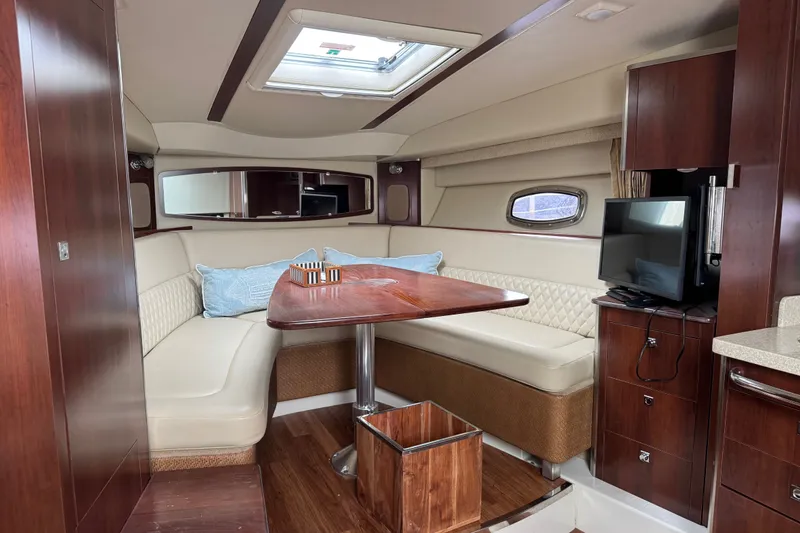 Slide: The Image of Interior of 2013 Chaparral 330 Signature yacht with elegant seating and wooden table. - 10