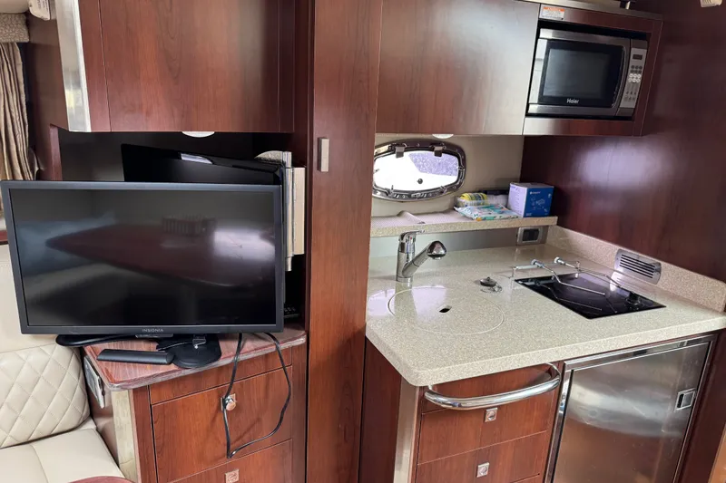 Slide: The Image of Interior of 2013 Chaparral 330 Signature yacht with kitchenette and TV setup. - 14