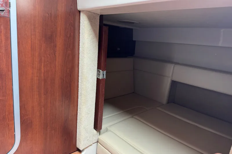 Slide: The Image of 2013 Chaparral 330 Signature cabin interior with wood paneling and cushioned seating. - 18