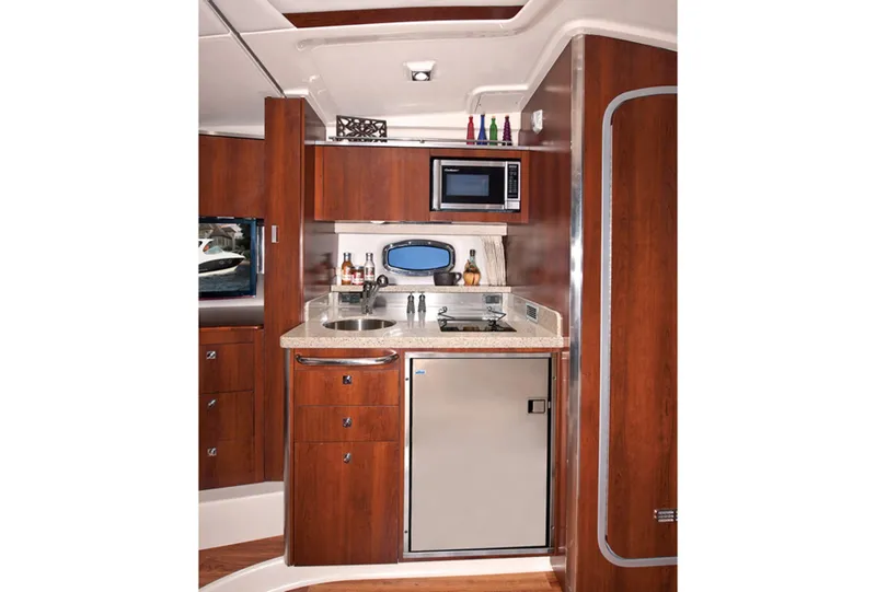 Slide: The Image of Manufacturer Provided Image: 2013 Chaparral 330 Signature yacht interior kitchen with microwave, sink, and refrigerator. - 29