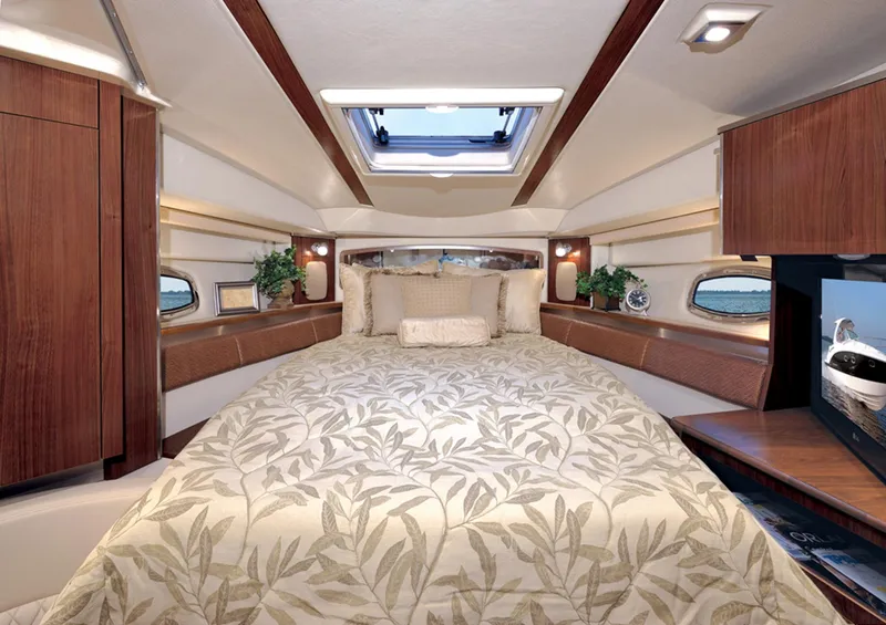 Slide: The Image of Manufacturer Provided Image: Luxurious 2013 Chaparral 330 Signature yacht cabin with elegant bedding and wooden accents. - 13