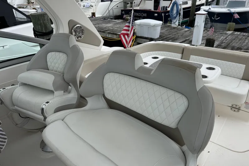 Slide: The Image of Luxury seating on a 2013 Chaparral 330 Signature boat at a marina. - 7