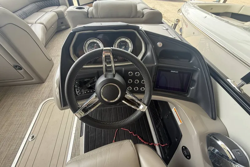 Slide: The Image of 2021 Barletta L25U boat dashboard with steering wheel and control panel. - 11
