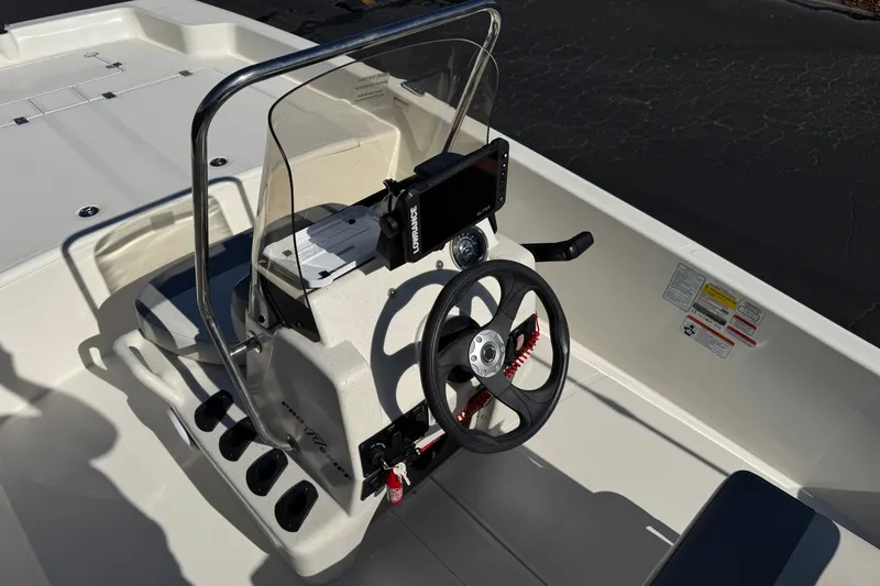 Slide: The Image of 2023 Mako Pro Skiff 17 CC boat console with steering wheel and navigation equipment. - 24
