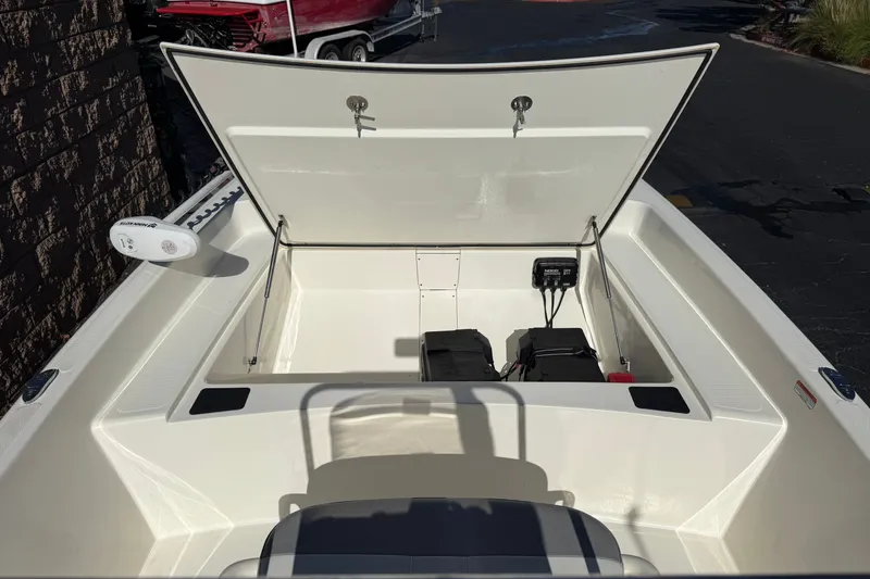 Slide: The Image of 2023 Mako Pro Skiff 17 CC boat with open storage compartment and equipment. - 13