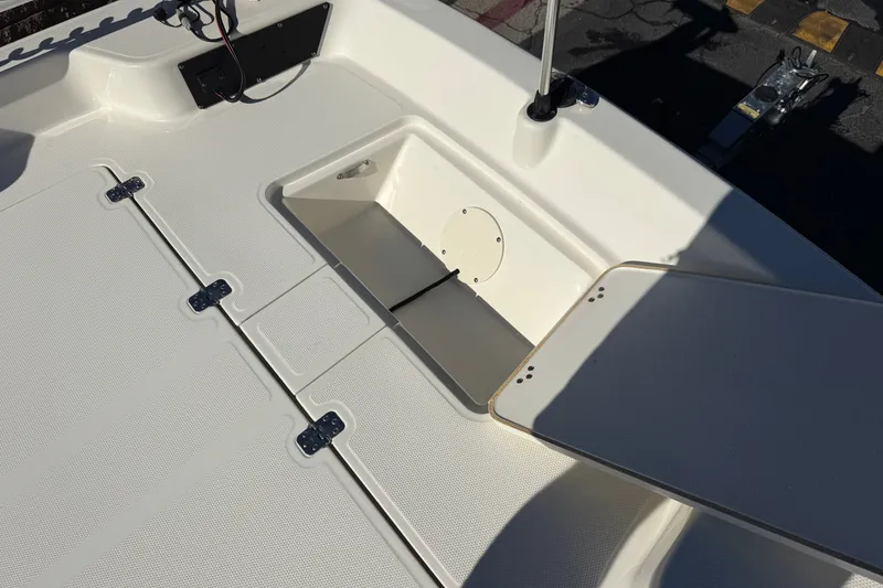 Slide: The Image of 2023 Mako Pro Skiff 17 CC boat deck with open storage compartment. - 12