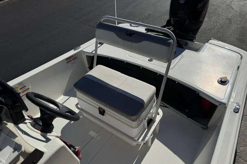 Slide: The Image of 2023 Mako Pro Skiff 17 CC boat interior with steering wheel and seating. - 19