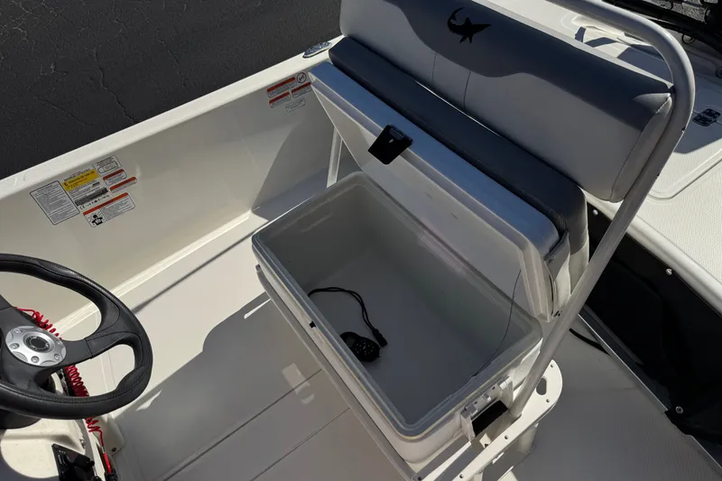 Slide: The Image of 2023 Mako Pro Skiff 17 CC interior with steering wheel and storage compartment. - 21