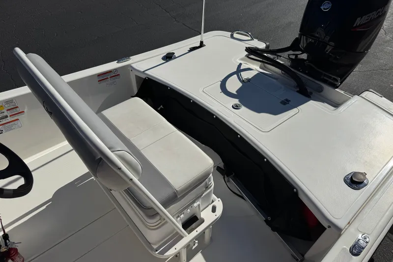 Slide: The Image of 2023 Mako Pro Skiff 17 CC boat interior with seating and motor, showcasing sleek design. - 20