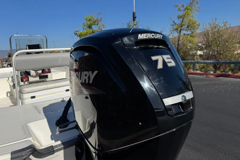 Slide: The Image of 2023 Mako Pro Skiff 17 CC with Mercury 75 outboard motor, parked outdoors. - 7