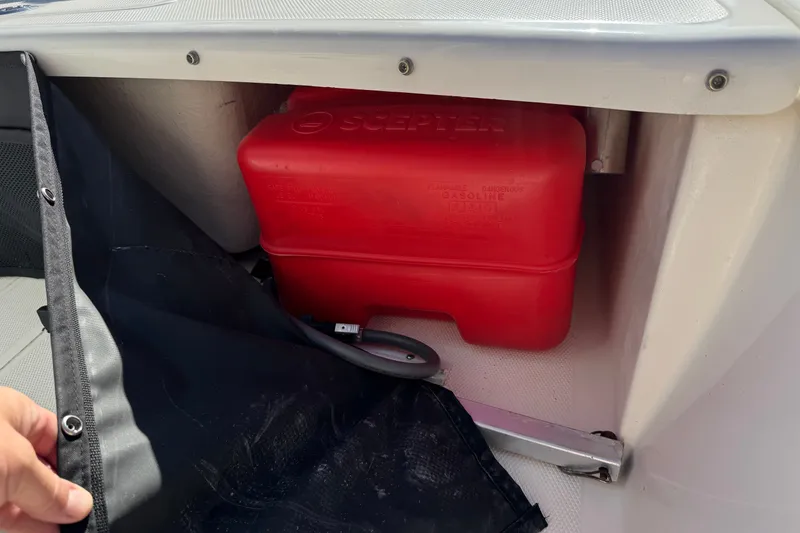 Slide: The Image of Storage compartment of 2023 Mako Pro Skiff 17 CC with red fuel tank. - 23