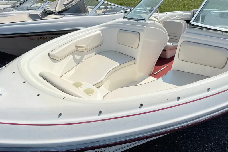 Slide: The Image of 1995 Searay 195 boat with white interior and red accents, docked outdoors. - 3